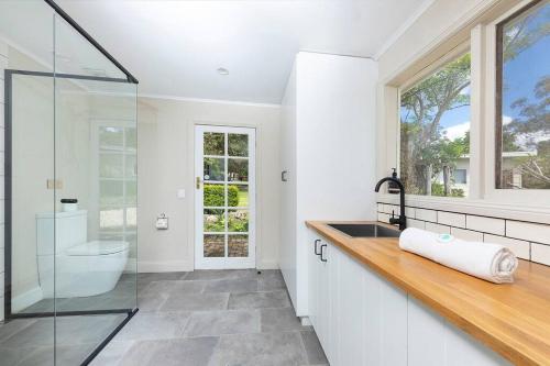 a bathroom with a glass shower and a sink at Katandra Homestead, farm on the lake, close to beaches and national park in Whoota