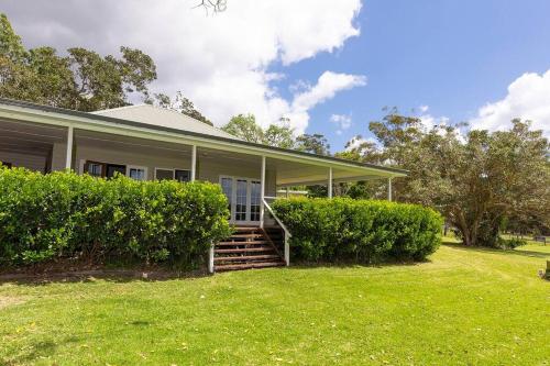 a house with a grass yard in front of it at Katandra Homestead, farm on the lake, close to beaches and national park in Whoota
