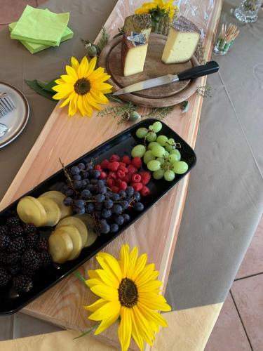 a tray of grapes and cheese and flowers on a table at Residence Garni Stella in San Vigilio Di Marebbe