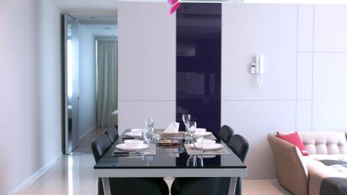 a dining room with a table and a couch at Verve Suites KL South in Kuala Lumpur