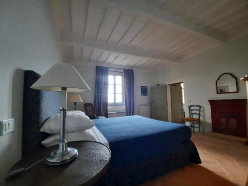una camera con un letto blu e una lampada sul tavolo di Belvedere Affittacamere a Città della Pieve