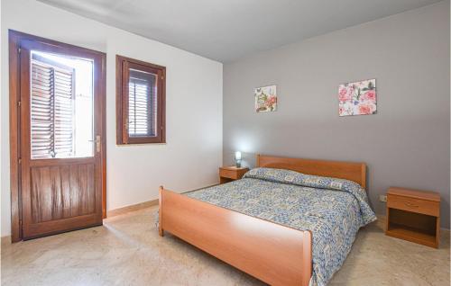 Schlafzimmer mit einem Bett, einem Fenster und einer Tür in der Unterkunft 2 Bedroom Gorgeous Apartment In Trappeto in Trappeto