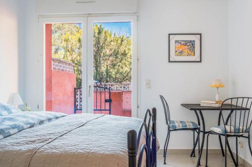 a bedroom with a bed and a table and chairs at Regina's Banyuls - 2 terraces, pool and private parking in Banyuls-sur-Mer