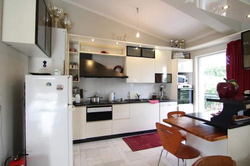 cocina blanca con mesa y nevera en Sea Side Villa Alexandra, en Alissos