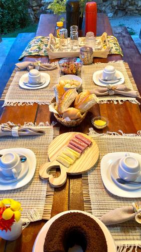 a wooden table with plates of food on it at CasaMares Macapá - Praia de Macapá in Macapá