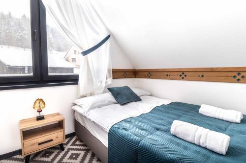a bedroom with a bed and a window at FAJNE CHATY - rodzinny wypoczynek w górach in Falsztyn