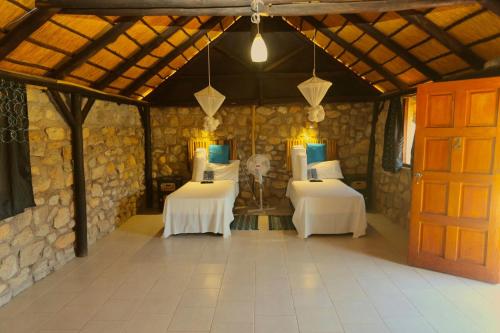 Una habitación con dos mesas y una puerta. en Kapika Waterfall Lodge, en Epupa