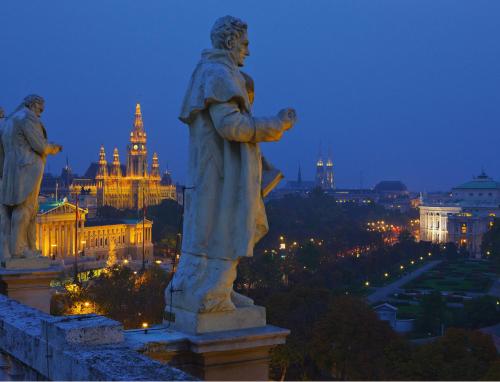 a statue of a man looking at a city at night at ARTIST Boutique Hotel in Vienna