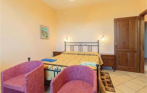 CasamaggioreにあるStunning Apartment In Castiglione Del Lago With 2 Bedrooms, Wifi And Outdoor Swimming Poolのベッドルーム1室(ベッド1台、椅子2脚付)