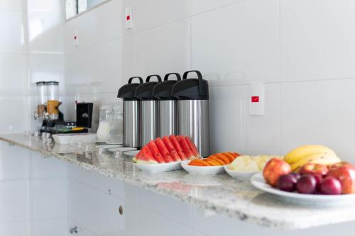 a counter with plates of fruits and vegetables on it at Hotel Mirante do Forte in Cabo Frio