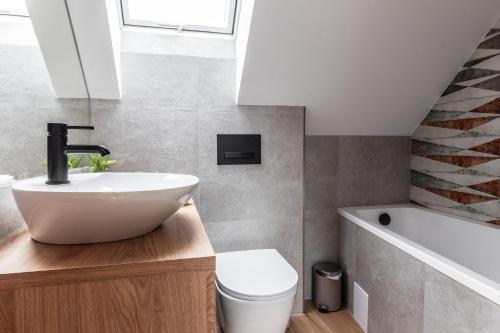 a bathroom with a sink and a toilet and a tub at FAJNE CHATY - rodzinny wypoczynek w górach in Falsztyn
