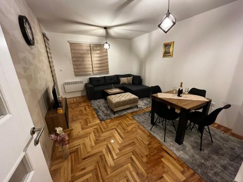 a living room with a black couch and a table at Ema Residence Pale Jahorina in Pale