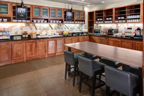 a kitchen with a table and chairs in a restaurant at Hyatt Place Albuquerque Airport in Albuquerque