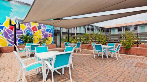 a patio with tables and chairs and a mural at Downtown Phoenix Hotel in Phoenix