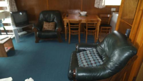 a living room with two leather chairs and a table at Lamont Chalet Self catering holiday homes Creagmhor Glenelg IV408LA in Glenelg