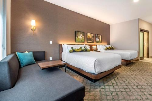 una camera d'albergo con due letti e un divano di Cambria Hotel Louisville Downtown-Whiskey Row a Louisville