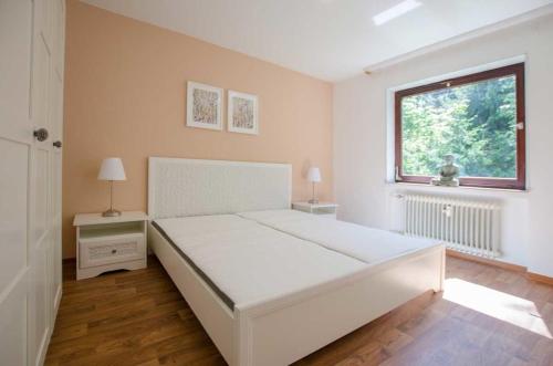 Un dormitorio blanco con una cama grande y una ventana en Ferienwohnung Amselnest en Bad Sachsa