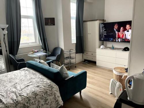 Schlafzimmer mit einem Bett und einem Flachbild-TV in der Unterkunft Studio Flat London Finchley Rd NW11 in London