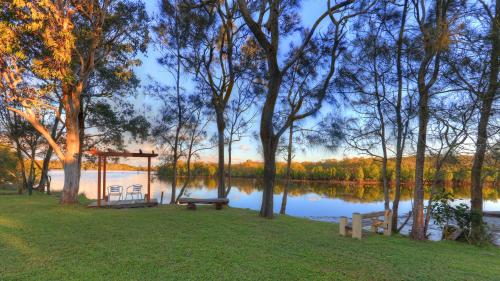 a park with a bench next to a lake at Wooli River Lodges in Wooli