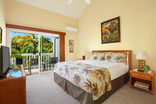 a bedroom with a large bed and a balcony at Regency 321 in Koloa