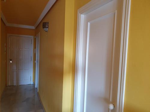 un corridoio con pareti gialle e porta bianca di Las Mimosas, La Cala de Mijas a La Cala de Mijas