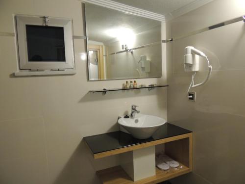a bathroom with a sink and a mirror at Akcayhan Hotel in Akçay