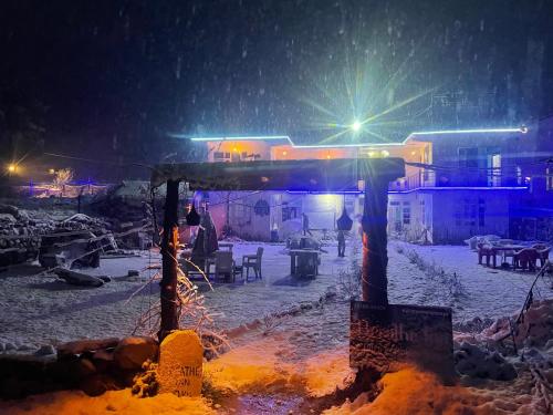 einen schneebedeckten Hof in der Nacht mit einem Bus in der Unterkunft Breathe Inn in Kasol