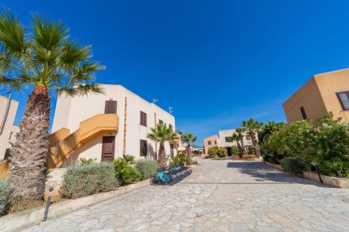ulica z palmami i budynek w obiekcie Elimi Favignana Apartments - Residence in città w mieście Favignana