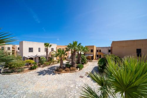 dziedziniec z palmami i budynkami w obiekcie Elimi Favignana Apartments - Residence in città w mieście Favignana