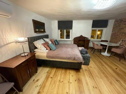 sypialnia z łóżkiem, stołem i krzesłami w obiekcie Mostowa Apartment w Toruniu