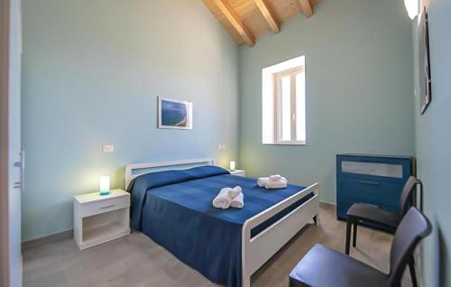 una camera con un letto blu e una sedia di Amazing Apartment In Patti With 2 Bedrooms, Wifi And Outdoor Swimming Pool a Patti