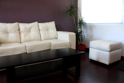 a living room with a white couch and a coffee table at Hostal Buró in Concepción