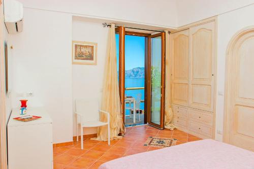 a bedroom with a door open to a balcony at Casa Cinque in Praiano