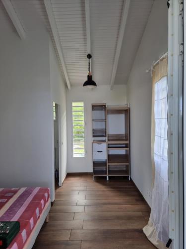 a room with a bed and a hallway with a window at Les hauts du Morne Larcher in Quartier du Fond Fleuri
