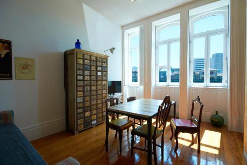 comedor con mesa, sillas y ventanas en Portas do Bolhão, en Oporto