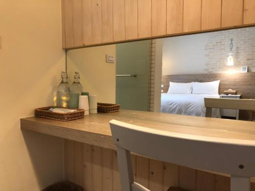 a room with a bed and a counter with a mirror at Daybreak in Taitung City