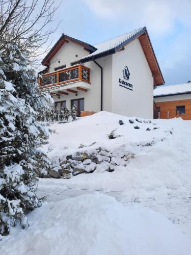 a building with snow in front of it at Karolowy pokoje&apartamenty in Ustroń