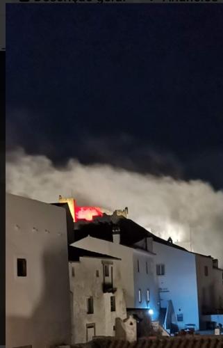 a building with a dark sky in the background at Casa O Arco Alojamento Local in Marvão