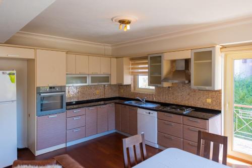 a kitchen with wooden cabinets and a table with chairs at Vira Suites Hotel in Göcek
