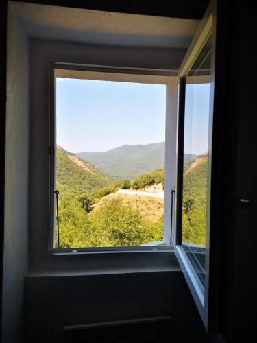 - une fenêtre avec vue sur la montagne dans l'établissement Maison de village avec jardin privatif, à Zicavo