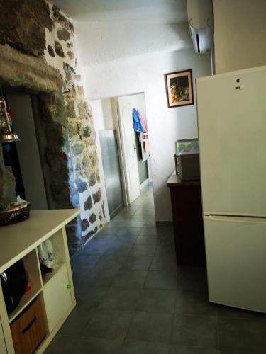 een keuken met een koelkast en een stenen muur bij Maison de village avec jardin privatif in Zicavo