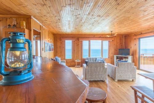 a living room with a large wooden table with a lamp at Strandhuis in Eersterivierstrand