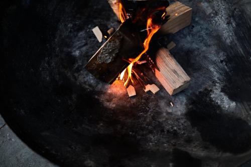 a fire in a grill with pieces of wood at AVA HOUSE in Kranjska Gora