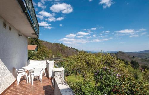 eine Terrasse mit zwei Stühlen und einem Tisch an einem Haus in der Unterkunft Il Cottage in Carro
