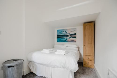 a bedroom with a white bed with towels on it at Hullidays-Theatre Hideout Apartment in Hull