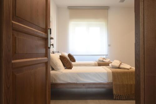 a bedroom with two beds and a window at Tenuta Micoli in Frisa