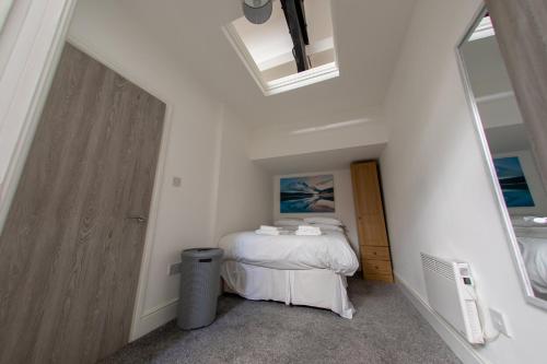 a small bedroom with a bed and a window at Hullidays-Theatre Hideout Apartment in Hull