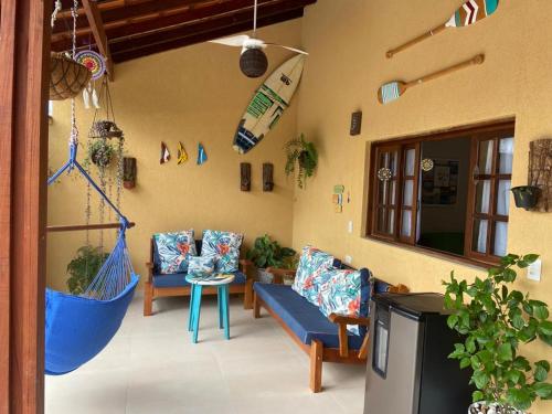 ein Wohnzimmer mit Sofas und einem TV in der Unterkunft casa 300 mts da praia in Juquei