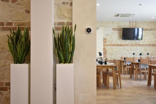 a dining room with two potted plants on the wall at Tenuta Micoli in Frisa