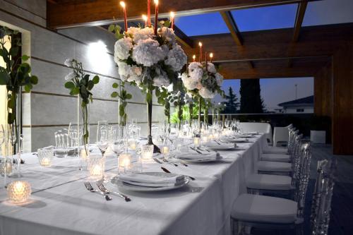 a long table with white plates and candles and flowers at Tenuta Micoli in Frisa
